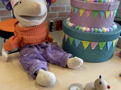 Klaspop Jules zit op tafel naast een taart, hij draagt een kroon.